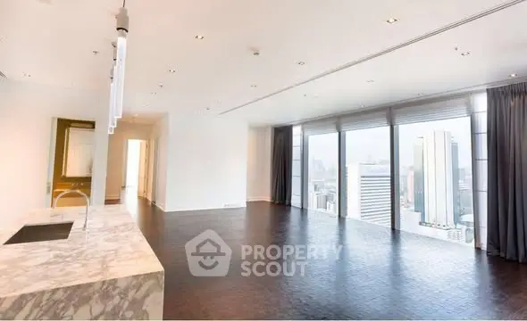 Luxurious open-plan living room with stunning city views and modern marble kitchen island.