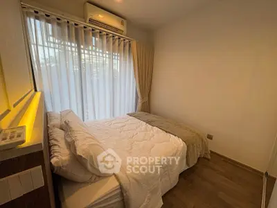 Cozy bedroom with natural light and modern decor, featuring a comfortable bed and elegant curtains.