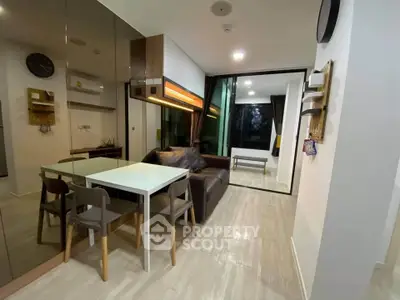 Modern living room with sleek furniture and mirrored wall in a stylish apartment.
