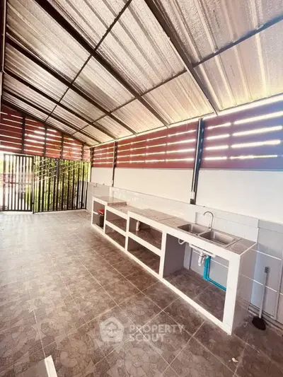 Spacious outdoor kitchen with open layout and modern design, perfect for entertaining guests.