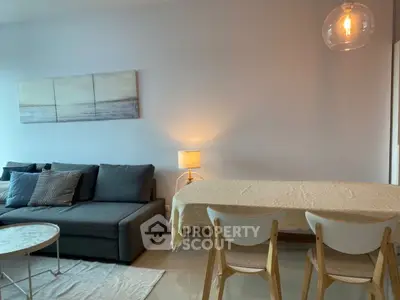 Modern living room with cozy sofa and dining area, featuring elegant lighting and minimalist decor.