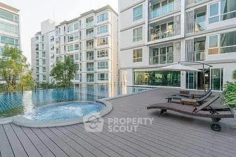 Luxurious apartment complex with pool and sun deck offering modern living amenities.