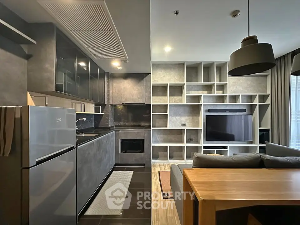 Modern open-layout kitchen and living room with sleek design and built-in shelving.