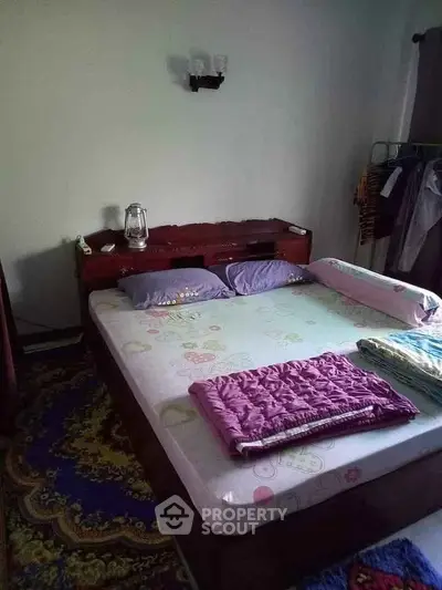 Cozy bedroom with wooden bed frame and colorful bedding, perfect for a restful night's sleep.