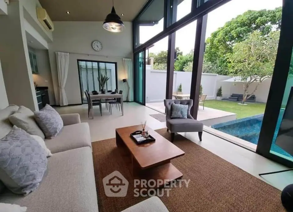 Luxurious living room with pool view and modern decor in a spacious open layout.
