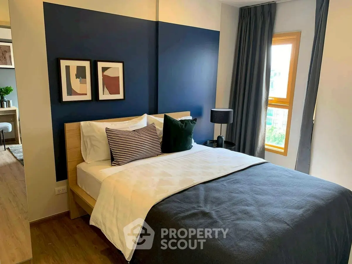 Modern bedroom with stylish decor and natural light in a cozy apartment.
