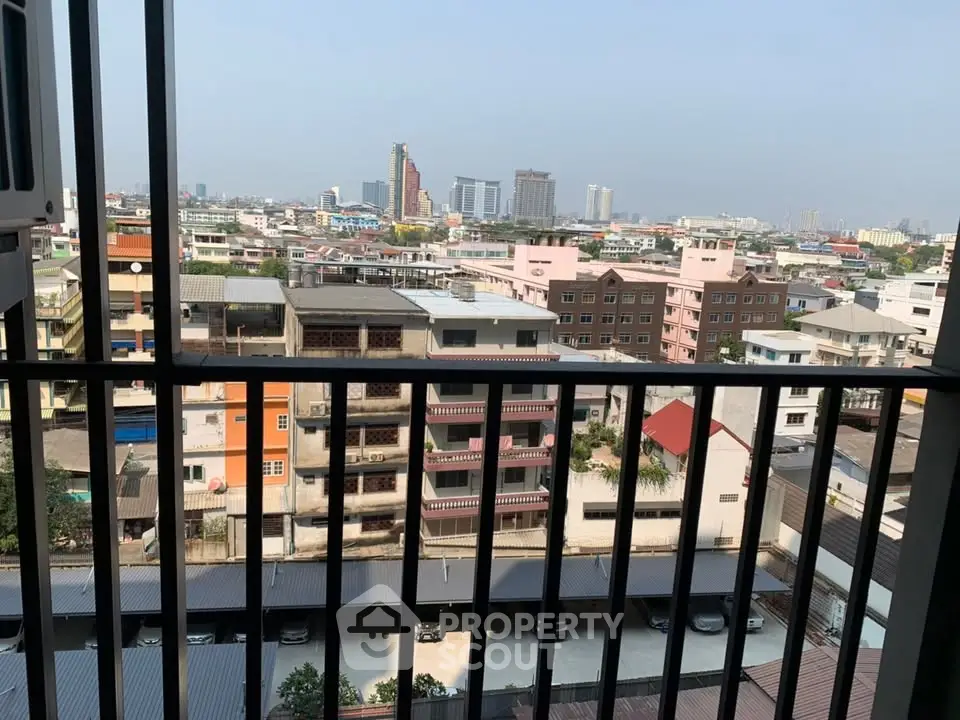 Stunning cityscape view from a high-rise balcony overlooking urban skyline and residential buildings.