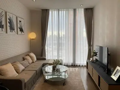 Modern living room with large windows, stylish decor, and comfortable seating in a high-rise apartment.
