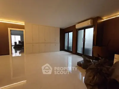 Spacious room with sleek built-in cabinets and large frosted glass doors, perfect for modern living.