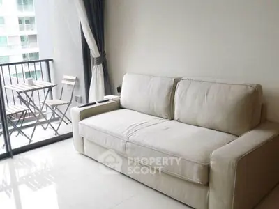 Modern living room with cozy sofa and balcony view in urban apartment.