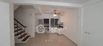 Spacious open-plan living area with modern kitchen and staircase