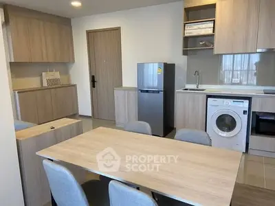 Modern kitchen with dining area, featuring wooden cabinetry and built-in appliances.
