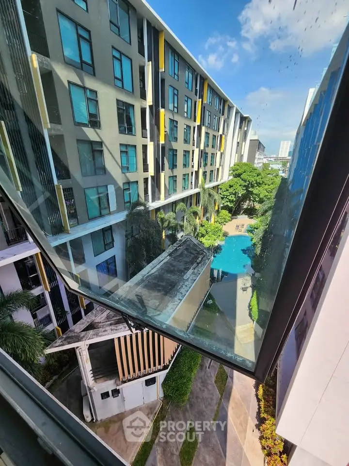 Modern apartment complex with pool view from upper floor window