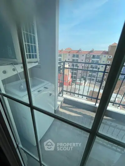 Charming balcony with laundry area and scenic view of colorful buildings.