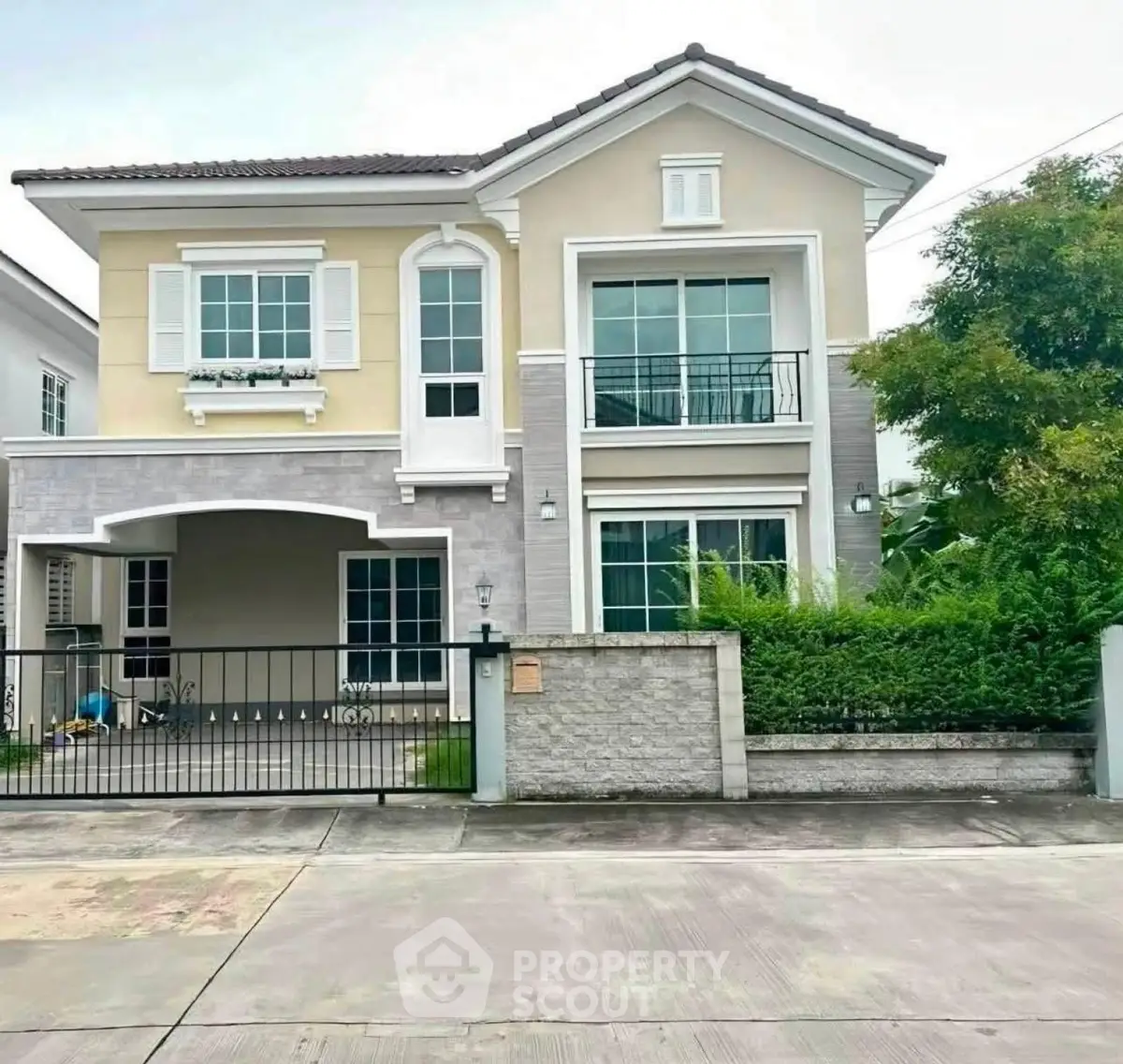 Charming two-story house with modern facade and lush greenery, perfect for family living.