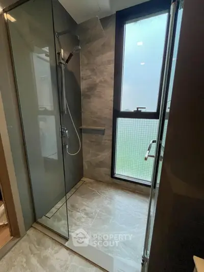 Modern bathroom with glass shower enclosure and large window