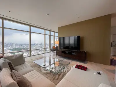 Luxurious living room with panoramic city views and modern furnishings in a high-rise apartment.