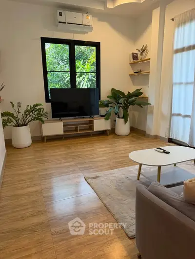 Spacious living room with modern decor and large window view