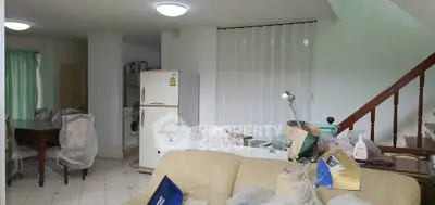 Spacious living room with dining area and staircase, featuring a fridge and washing machine.