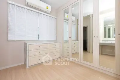 Spacious bedroom with mirrored wardrobes and sleek wooden flooring