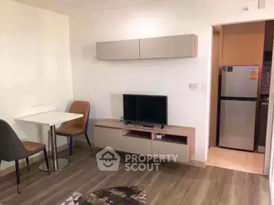 Modern living room with sleek furniture and compact kitchen area, perfect for urban living.