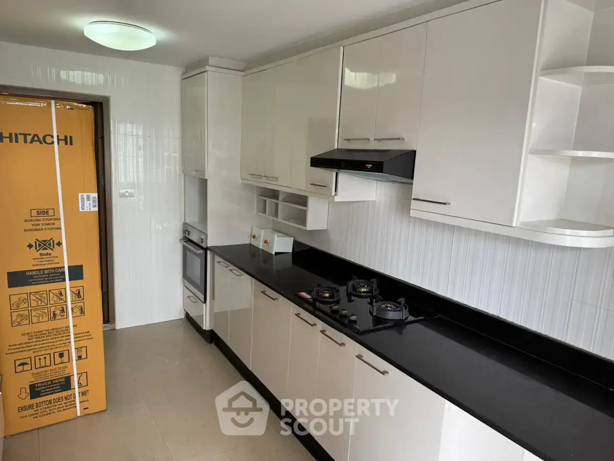 Modern kitchen with sleek cabinetry and gas stove in a contemporary apartment.
