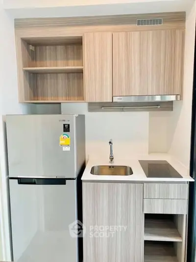 Modern kitchen with sleek appliances and minimalist design, featuring a built-in oven and stylish cabinetry.