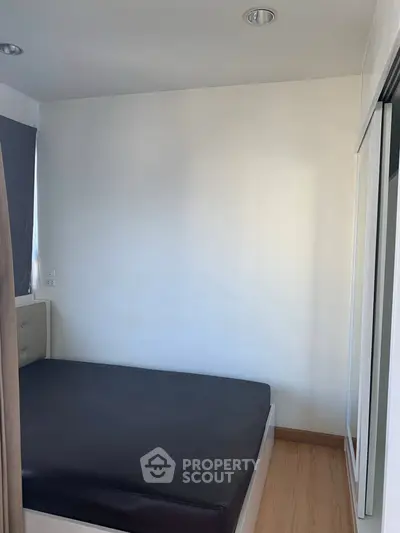 Cozy minimalist bedroom with modern design and ample natural light.