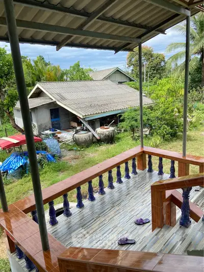Charming rural home with spacious balcony and lush garden view.