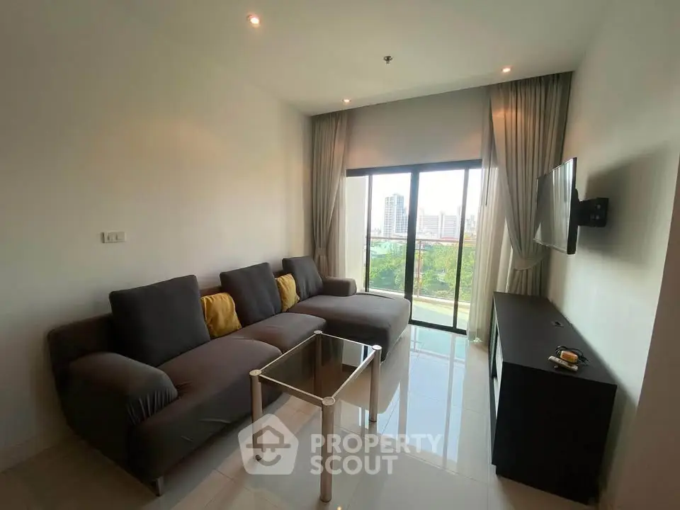 Modern living room with sleek furniture and city view from large windows.