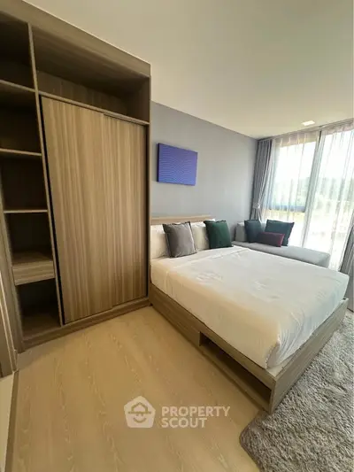 Modern bedroom with stylish wooden wardrobe and large window view