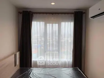 Cozy bedroom with large window and city view, featuring modern air conditioning and elegant curtains.