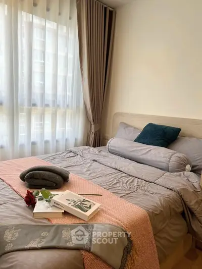 Cozy bedroom with elegant decor and natural light, featuring plush bedding and stylish curtains.
