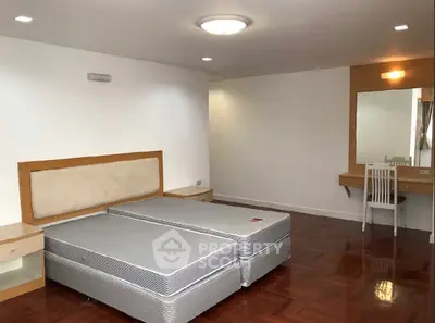 Spacious bedroom with hardwood floors and modern furniture