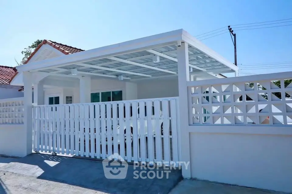 Charming white exterior with covered parking and modern fence design