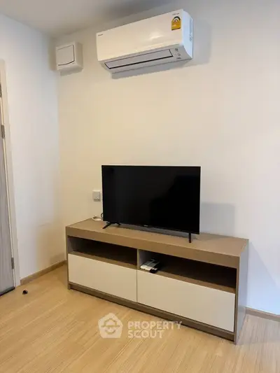 Modern living room with sleek TV stand and air conditioning unit, perfect for cozy entertainment.