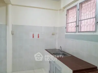 Simple kitchen with tiled walls and single sink, ideal for compact living spaces.