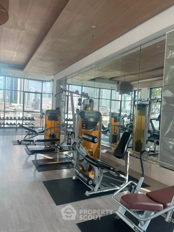 Modern gym with state-of-the-art equipment and city view, perfect for fitness enthusiasts.