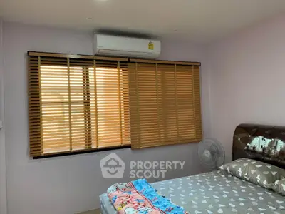 Cozy bedroom with air conditioning and wooden blinds for comfort and privacy.