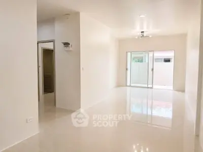 Spacious modern living room with glossy floors and large windows for natural light.