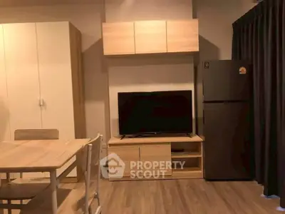 Modern living room with wooden furniture and sleek appliances in a cozy apartment setting.