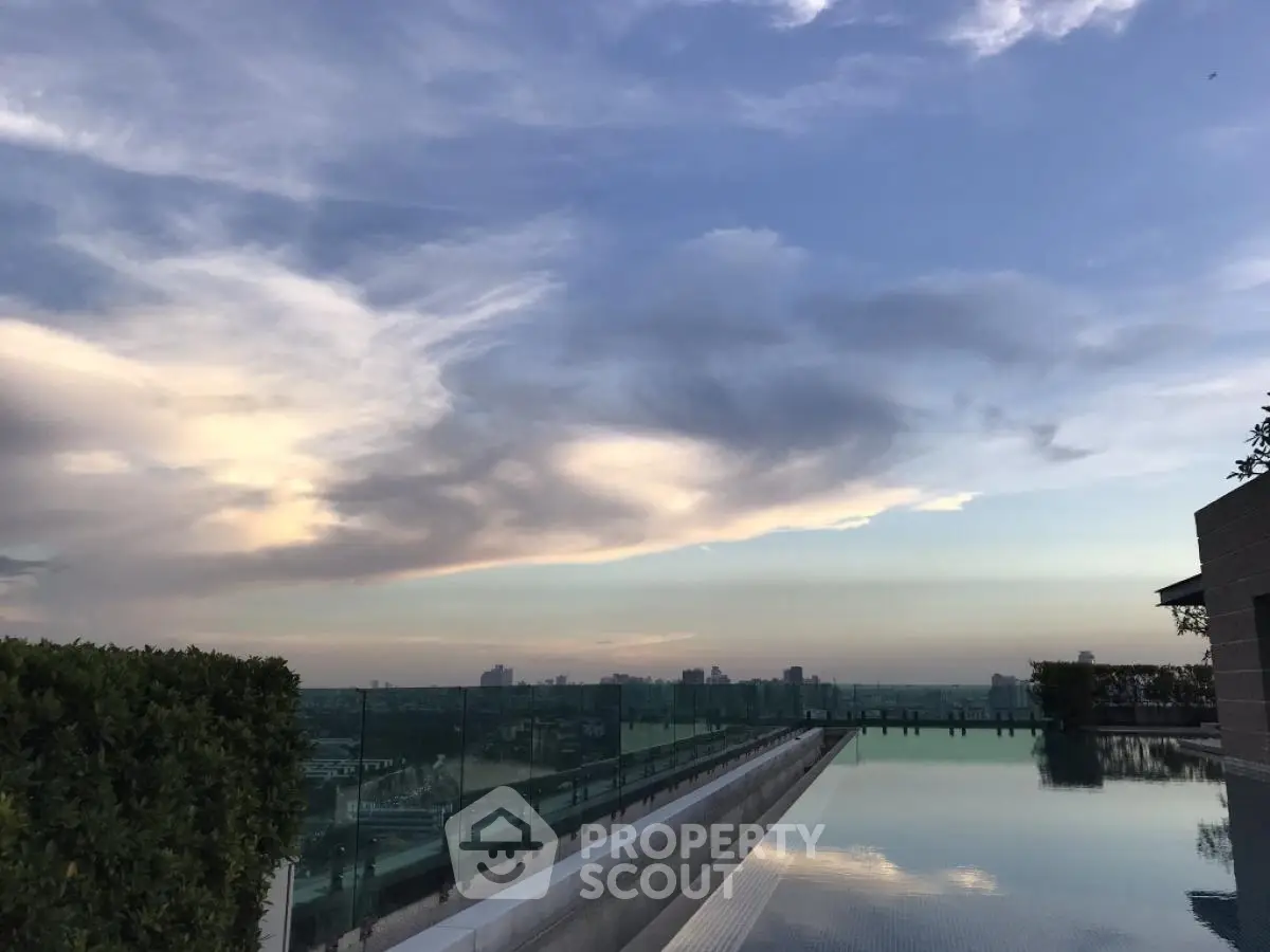 Stunning rooftop infinity pool with panoramic city skyline view at sunset