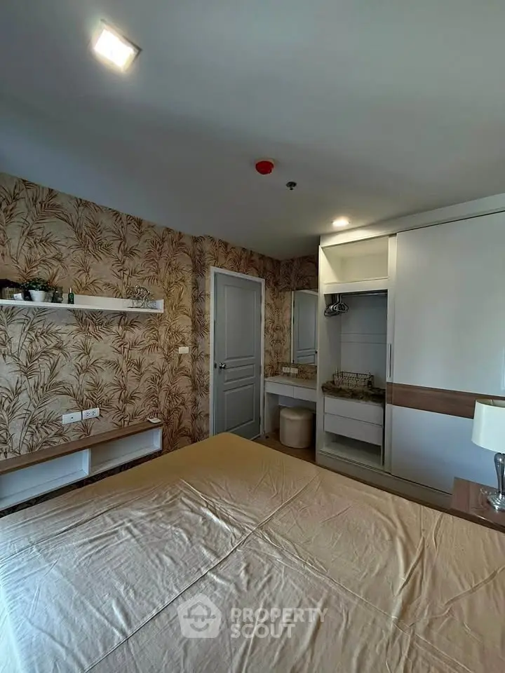 Stylish bedroom with modern decor and ample storage in a cozy apartment.