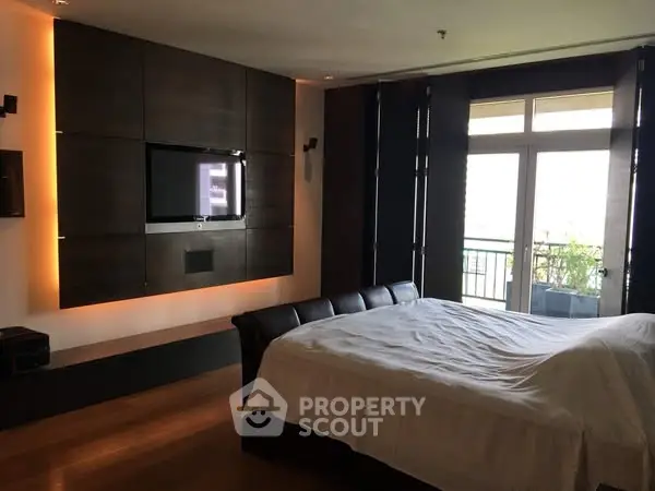 Luxurious bedroom with modern design and large windows opening to a balcony.