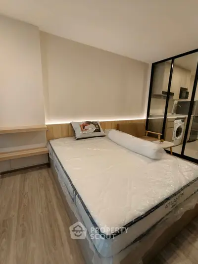 Modern bedroom with glass partition and in-unit laundry facilities