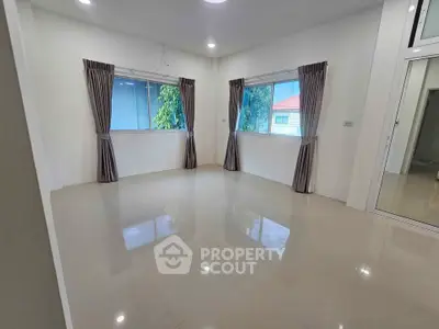 Spacious empty room with large windows and glossy tiled floor, perfect for customization.