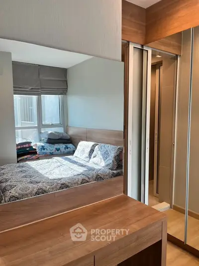 Modern bedroom with mirrored wardrobe and natural light