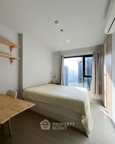 Bright and cozy bedroom with city view, featuring modern furnishings and ample natural light.