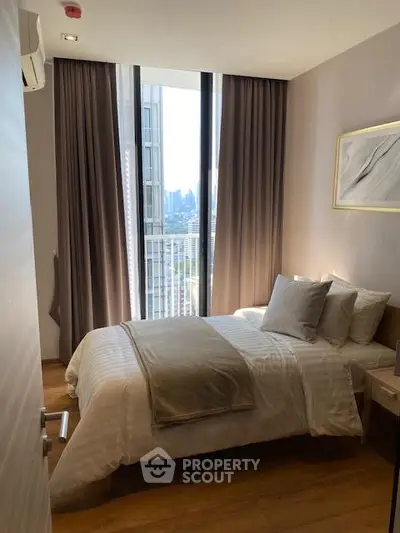 Modern bedroom with city view, featuring cozy bed and elegant decor.