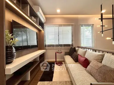 Modern living room with stylish decor, large sofa, and wall-mounted TV, perfect for relaxation and entertainment.